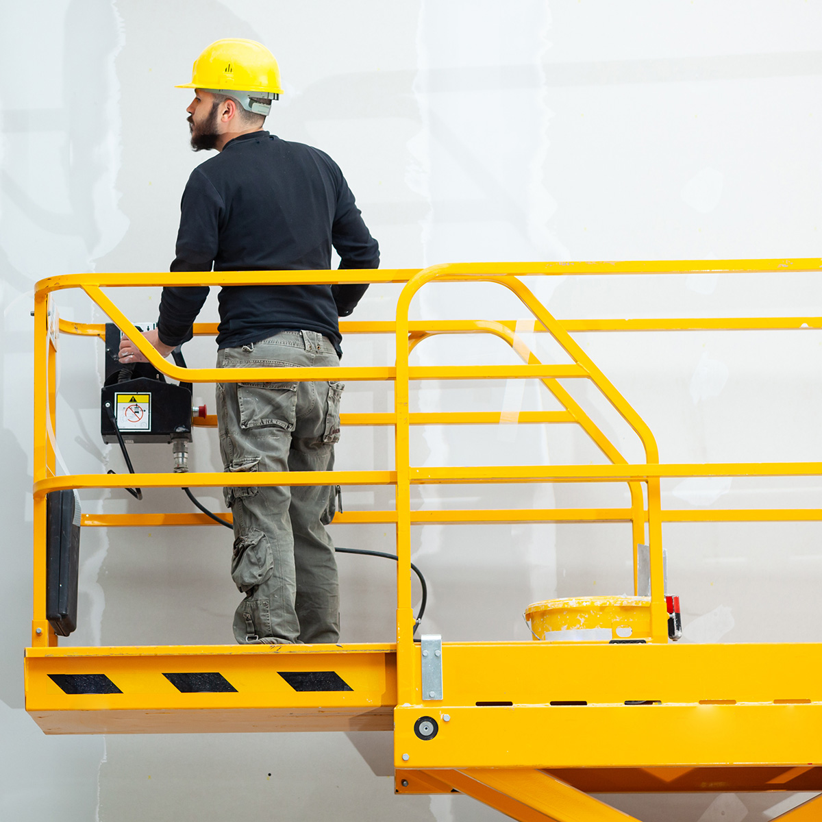 worker plastering gypsum board wall.